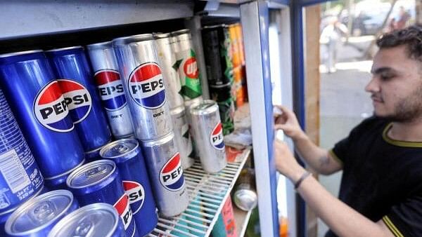 <div class="paragraphs"><p>An Egyptian supermarket owner arranges cans of soft drinks by PepsiCo on a shelf in Cairo, Egypt.&nbsp;</p></div>