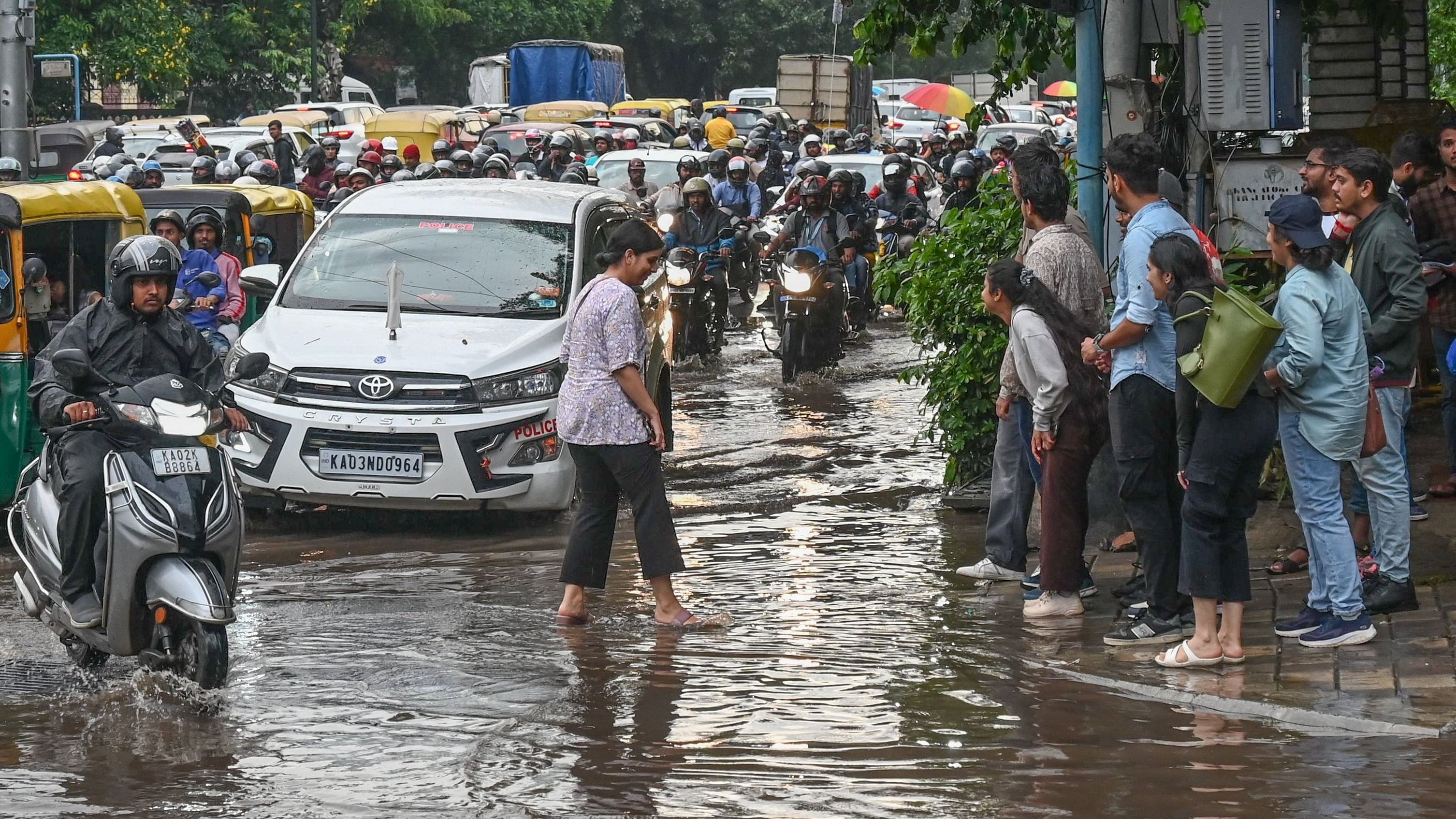 <div class="paragraphs"><p>Pedestrians wait as rain leads to traffic delays at Anil Kumble Circle. </p></div>