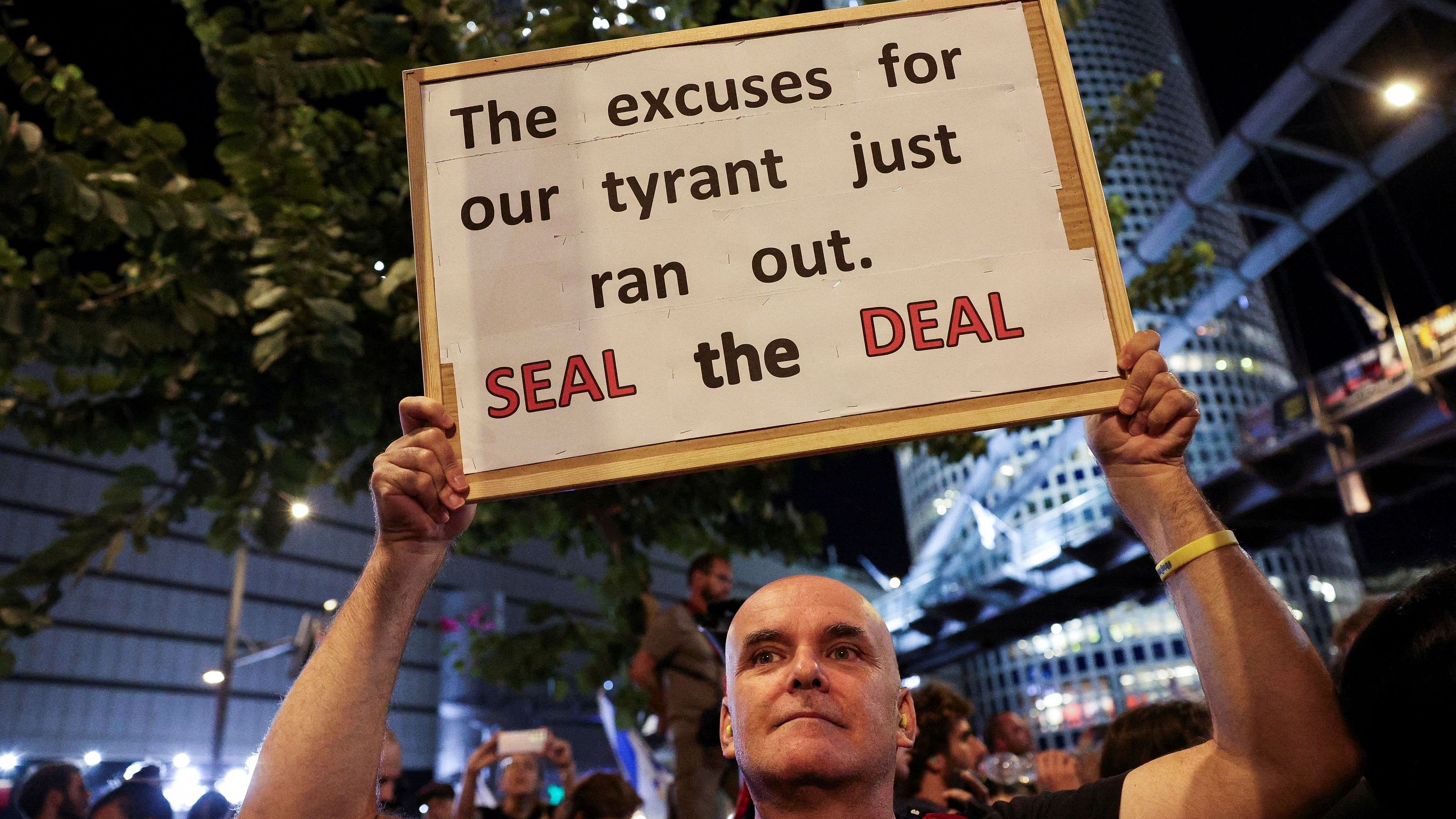 <div class="paragraphs"><p>A demonstrator holds a sign, as people protest against the government, to demand a ceasefire deal and the immediate release of hostages kidnapped during the deadly October 7, 2023 attack by Hamas, in Tel Aviv, Israel.</p></div>