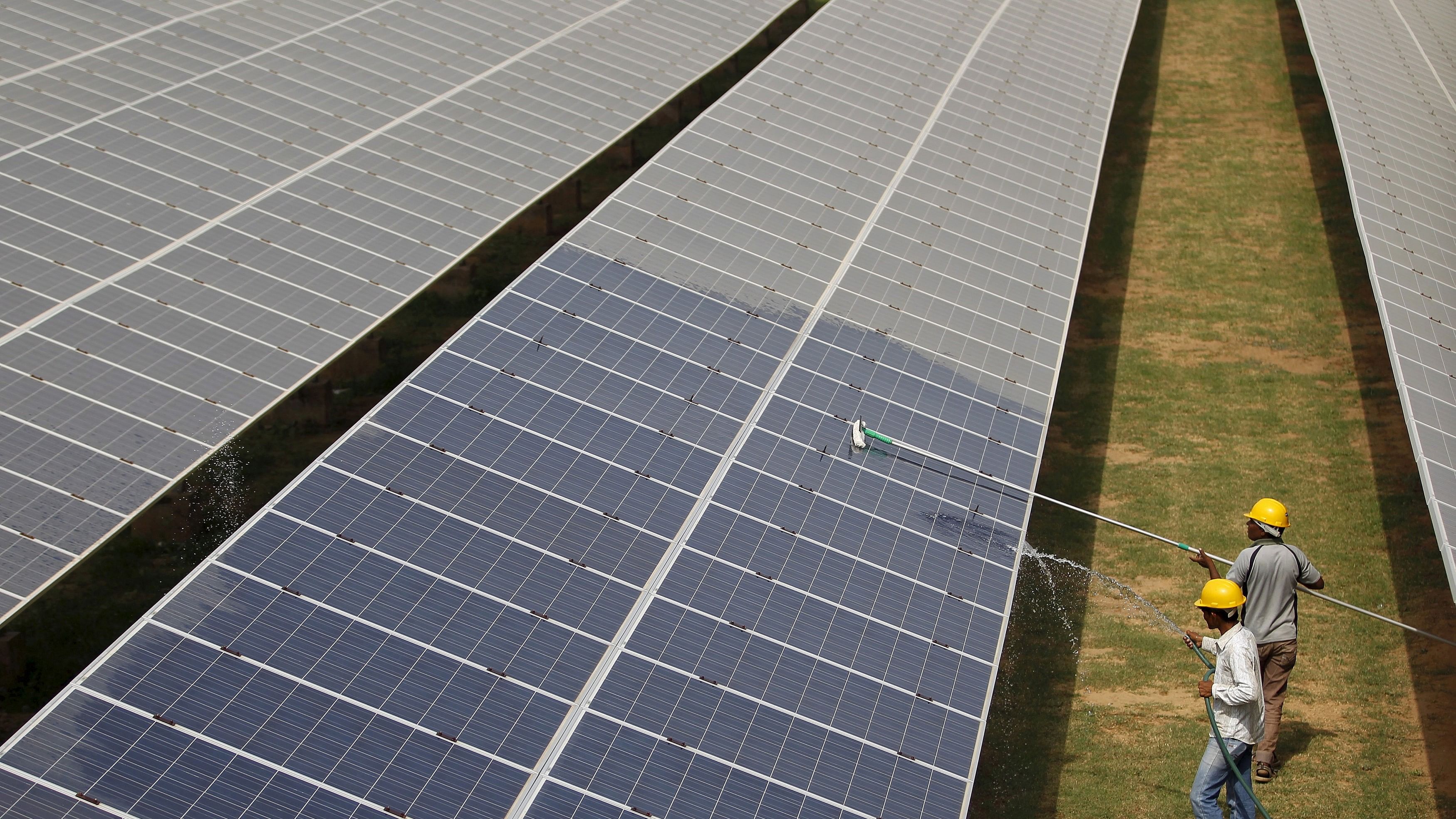 <div class="paragraphs"><p> Workers clean photovoltaic panels inside a solar power plant in Gujarat, India.</p></div>