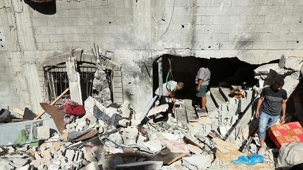 <div class="paragraphs"><p>Palestinians inspect the site of an Israeli strike on a house, amid the ongoing Israel-Hamas conflict, in Al Maghazi refugee camp in the central Gaza Strip.&nbsp;</p></div>