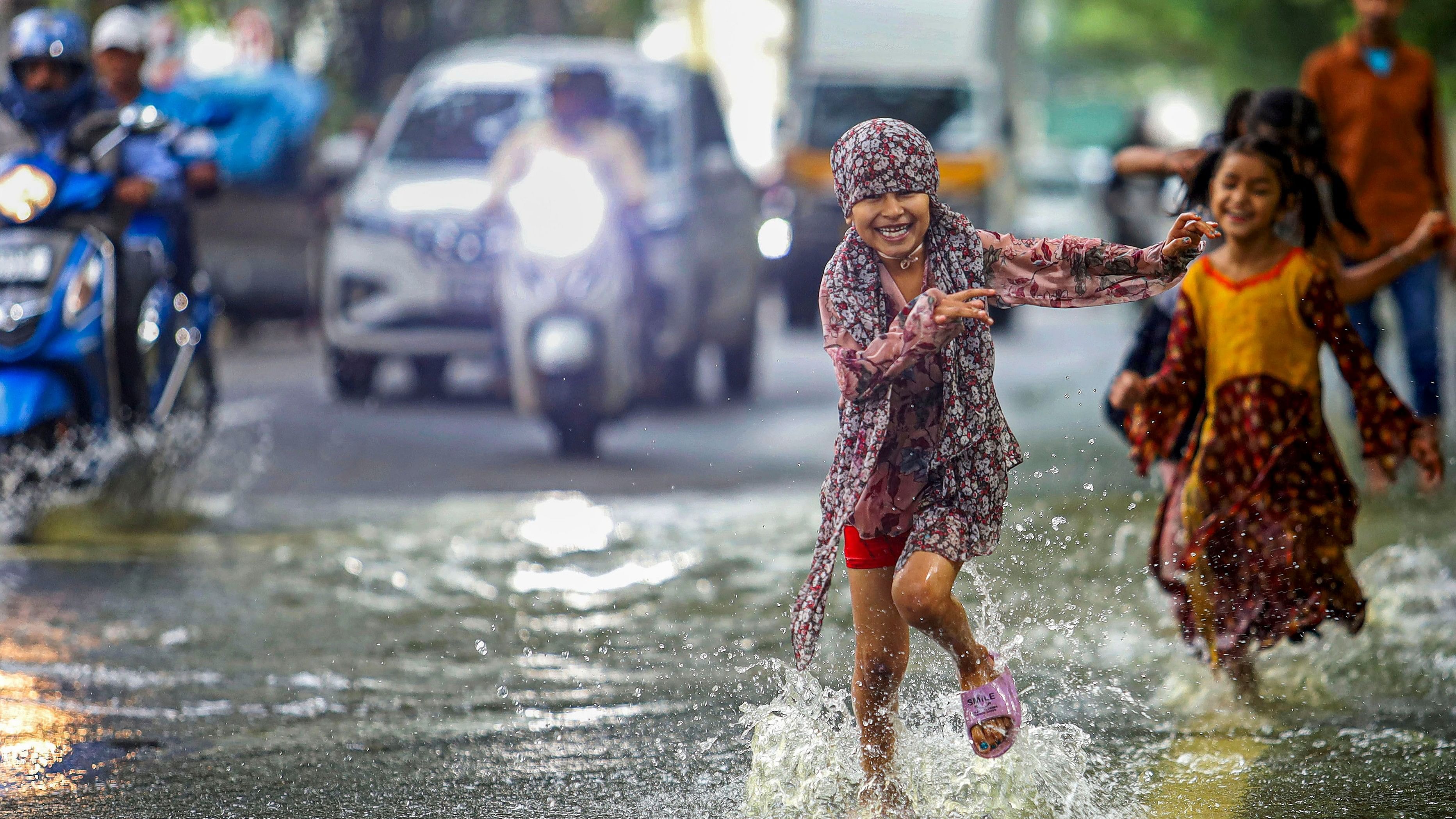 <div class="paragraphs"><p>Children play on a waterlogged road after torrential rain in Bengaluru on Monday. </p></div>