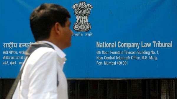 <div class="paragraphs"><p>A man walks past a signboard of the National Company Law Tribunal (NCLT).</p></div>