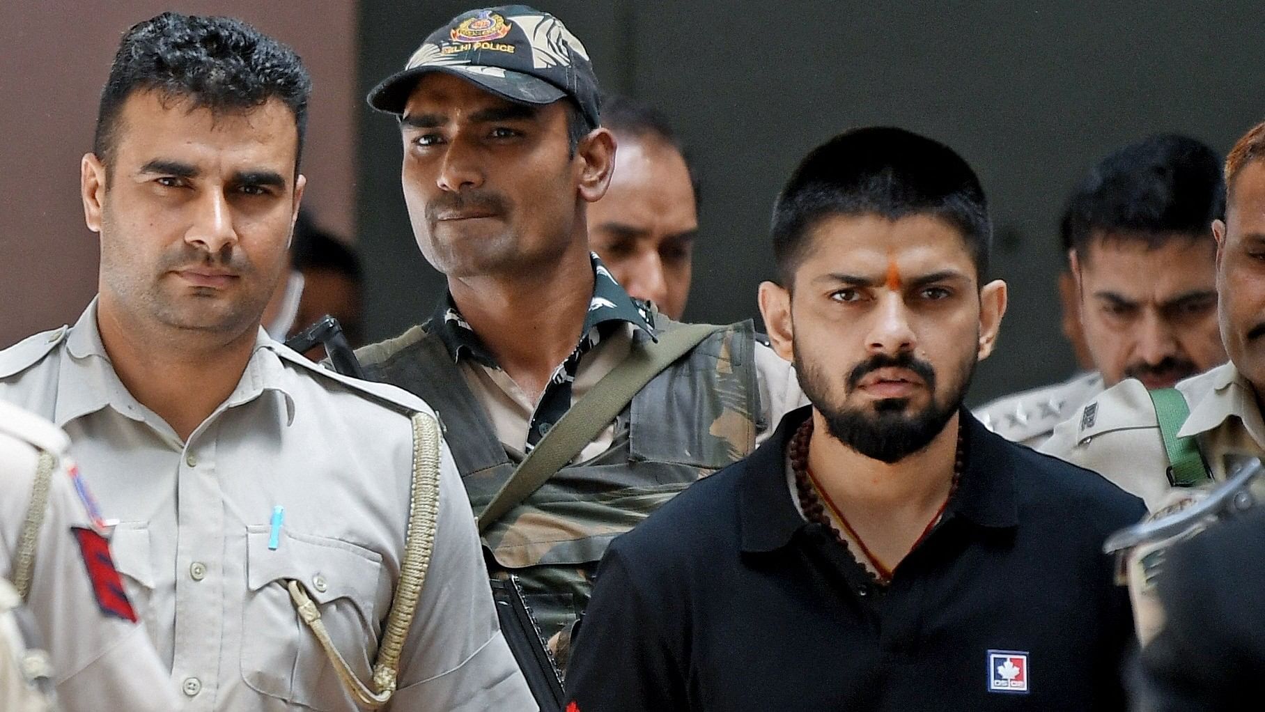 <div class="paragraphs"><p>Policemen escort Lawrence Bishnoi at a court in New Delhi.</p></div>