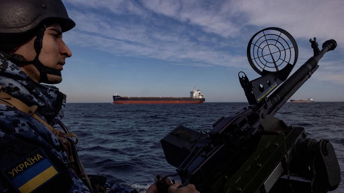 <div class="paragraphs"><p>A serviceman of Ukraine's coast guard mans a gun on a patrol boat as a cargo ship passes by in the Black Sea, amid Russia’s attack on Ukraine.</p></div>