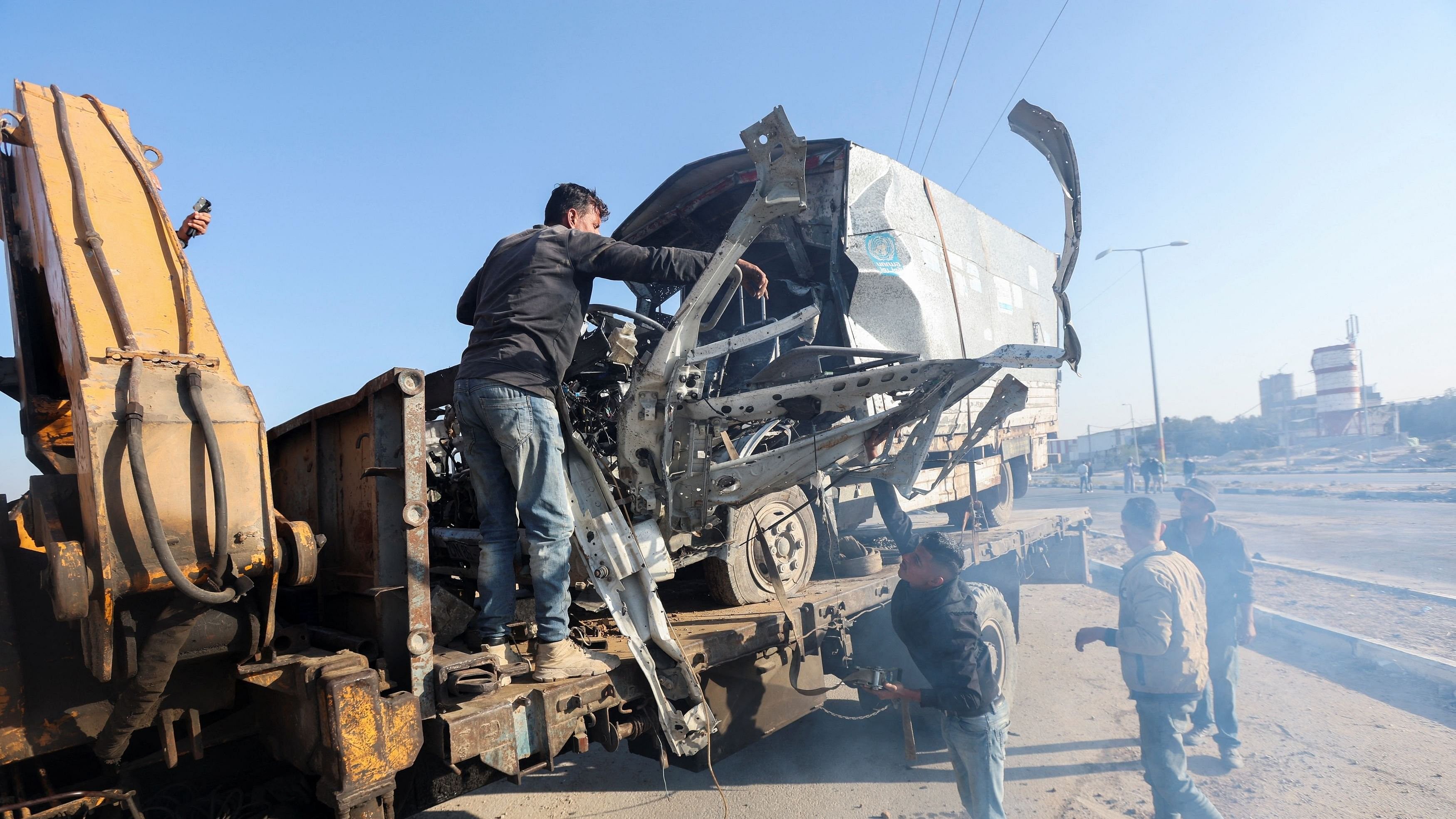 <div class="paragraphs"><p>Palestinians work to remove an UNRWA-labelled vehicle after it was hit in an Israeli strike, according to Palestinian officials, amid the Israel-Hamas conflict, in Deir Al-Balah in the central Gaza Strip.</p></div>