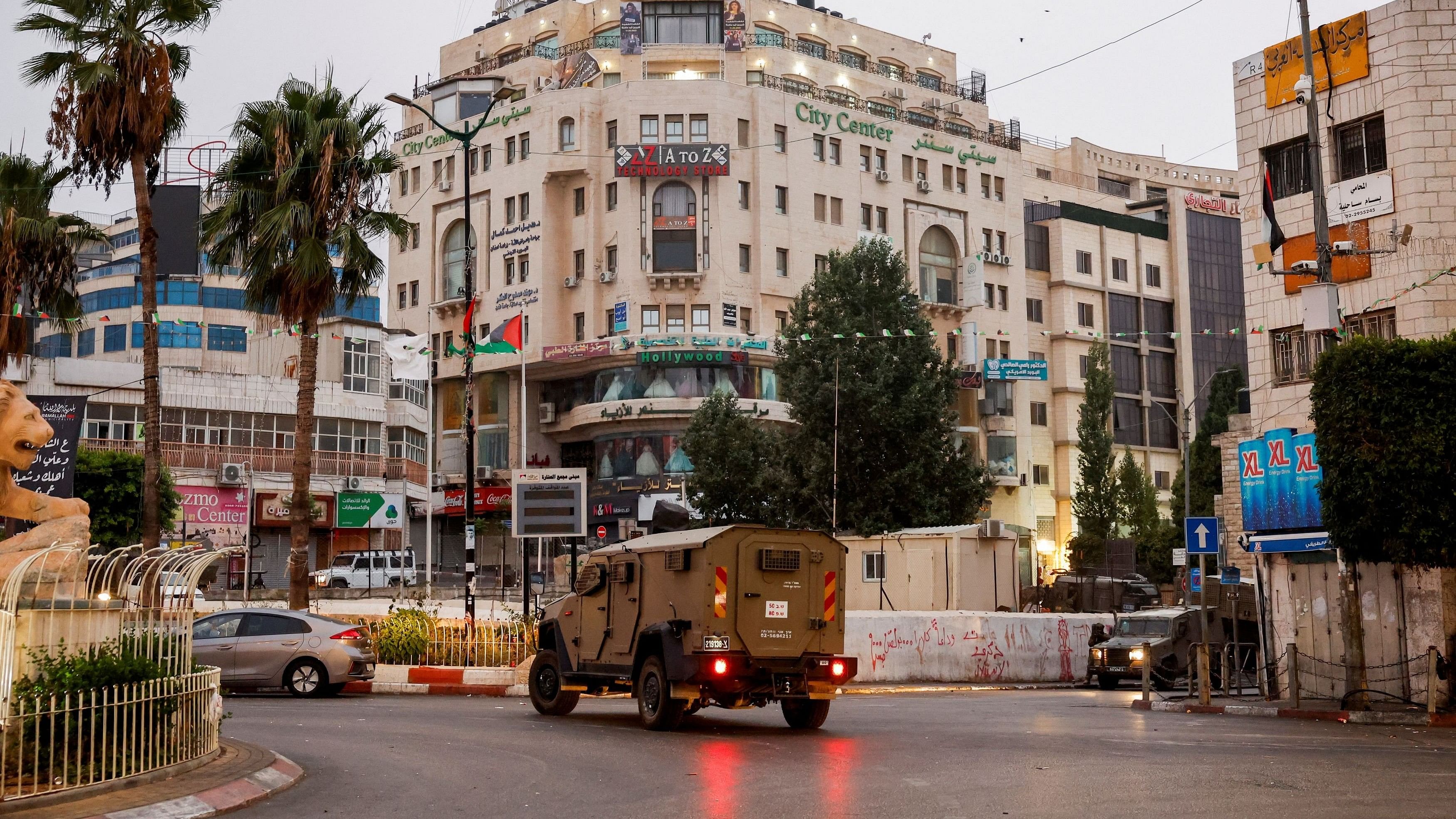 <div class="paragraphs"><p>A military vehicle moves in a street outside the building where the Al Jazeera office is located, in Ramallah, in the Israeli-occupied West Bank.</p></div>