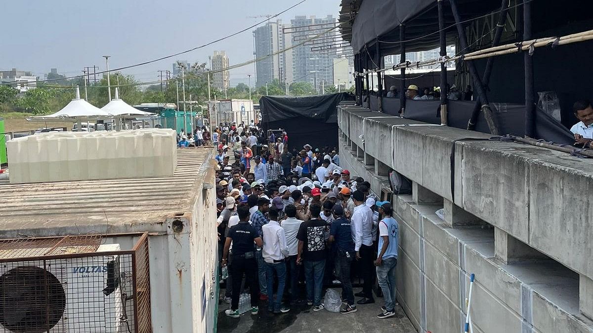 Spectators wait beyond the barricade for water to be supplied.