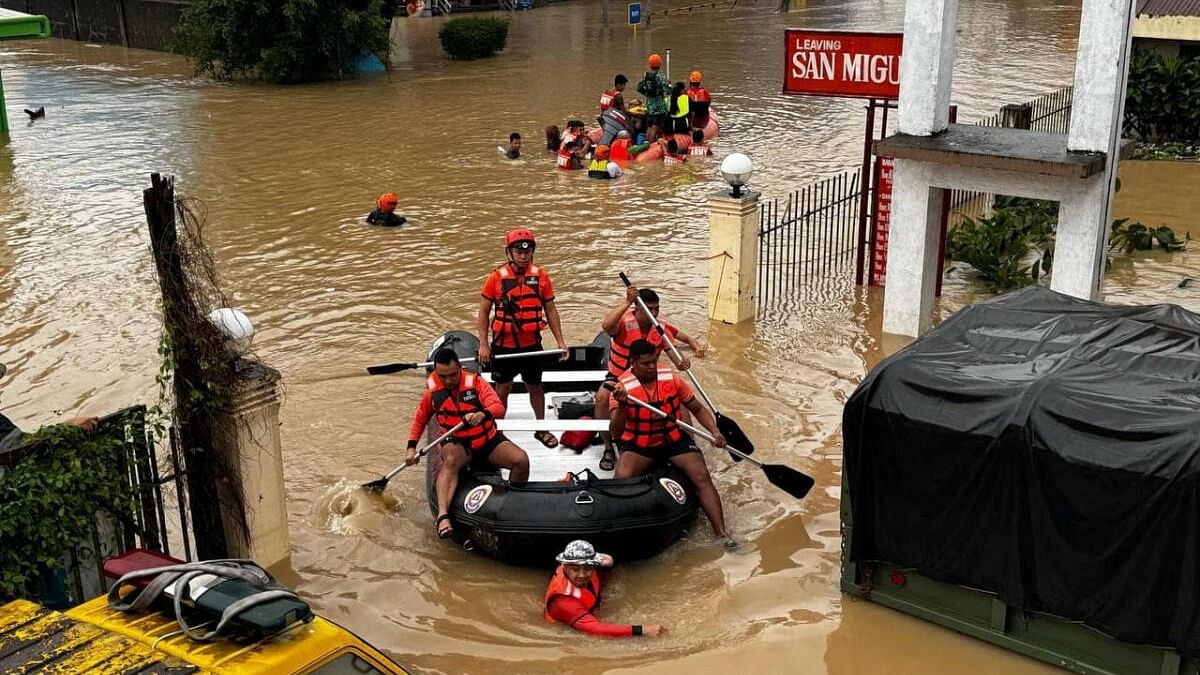 <div class="paragraphs"><p>Philippine Coast Guard personnel evacuate residents after flood waters rose due to heavy rains brought by Tropical Storm Trami in Camarines Sur, Philippines.</p></div>