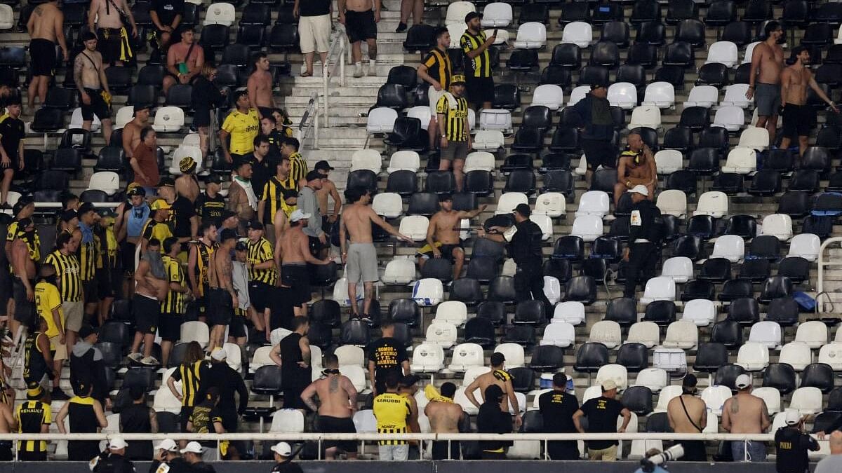 <div class="paragraphs"><p>Penarol fans clash with police officers in the stands after the match.</p></div>