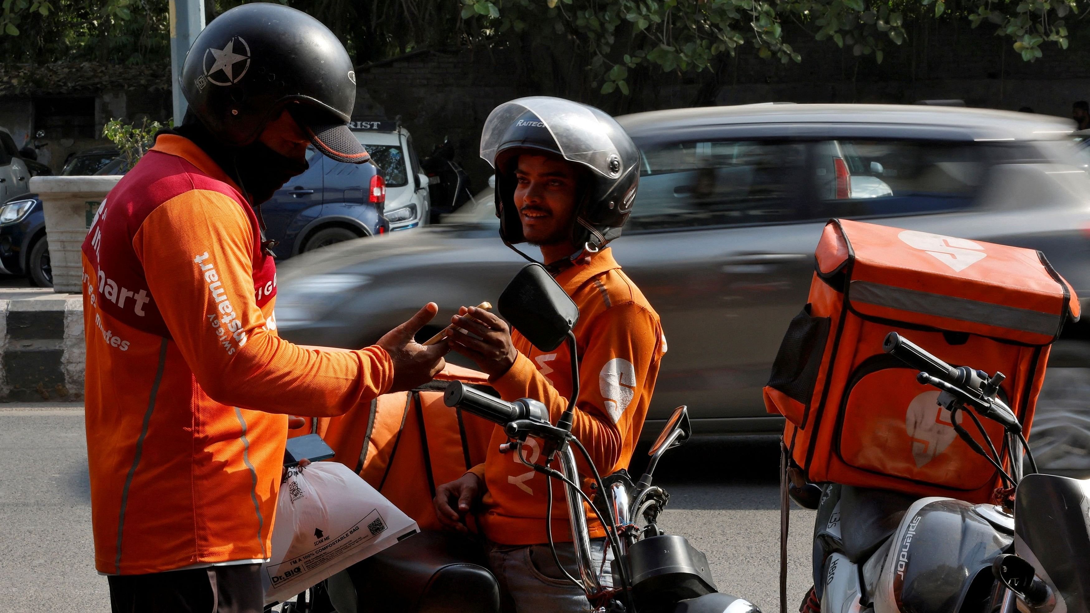 <div class="paragraphs"><p>Gig workers prepare to deliver orders outside Swiggy's grocery warehouse at a market area in New Delhi.</p></div>