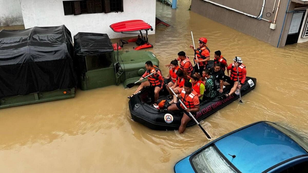 <div class="paragraphs"><p>Philippine Coast Guard personnel evacuate residents after flood waters rose due to heavy rains brought by Tropical Storm Trami in Camarines Sur, Philippines October 24, 2024.</p></div>