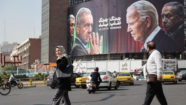 <div class="paragraphs"><p>Iranians walk next to an anti-U.S. and Israeli billboard with pictures of Iranian President Masoud Pezeshkian and Iranian Armed Forces Chief of Staff, Major General Mohammad Bagheri and U.S. President Joe Biden and Israel's Prime Minister Benjamin Netanyahu, on a street in Tehran, Iran, October 27</p></div>