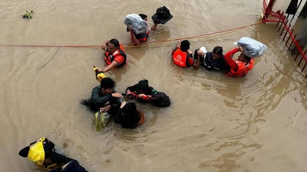 <div class="paragraphs"><p>Philippine Coast Guard personnel evacuate residents after flood waters rose due to heavy rains brought by Tropical Storm Trami in Camarines Sur, Philippines.&nbsp;</p></div>