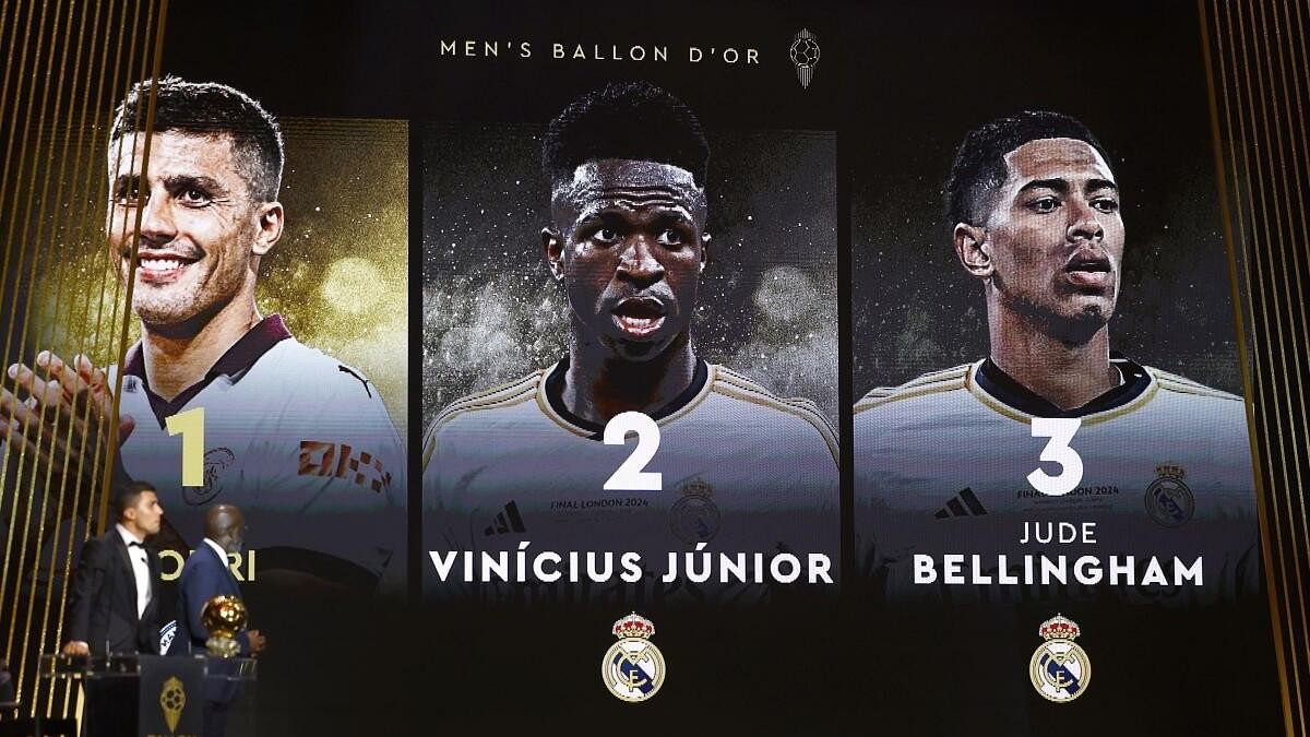 <div class="paragraphs"><p>Spain's and Manchester City's Rodri receives the Ballon d'Or from George Weah as showing on the screen the second Vinicius Junior and third and Jude Bellingham, no Real Madrid member attended the ceremony.</p></div>