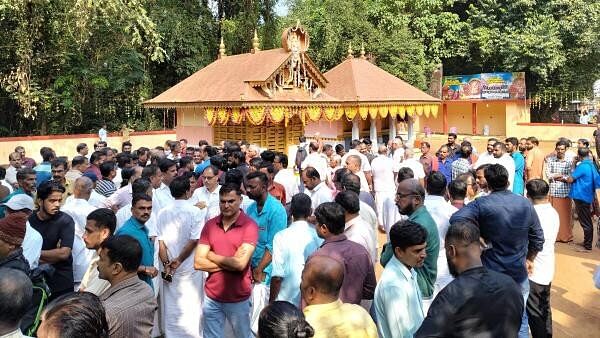 <div class="paragraphs"><p>People gather at the fire accident spot at the Anjootambalam Veererkavu Temple at Neeleswaram in Kasaragod district, Tuesday.&nbsp;</p></div>