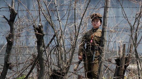 <div class="paragraphs"><p>FILE PHOTO: A North Korean prison policewoman stands guard behind fences at a jail on the banks of Yalu River near the Chongsong county of North Korea, opposite the Chinese border city of Dandong.&nbsp;</p></div>