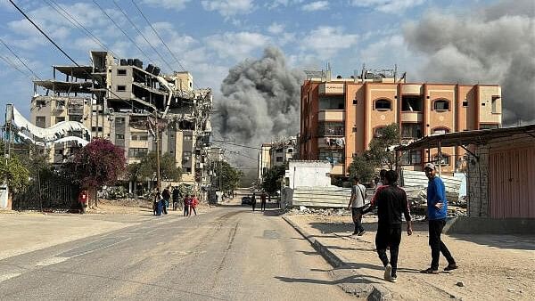 <div class="paragraphs"><p>Palestinians watch as smoke rises following Israeli strikes, amid the ongoing conflict between Israel and Hamas, in Nuseirat in the central Gaza Strip.</p></div>