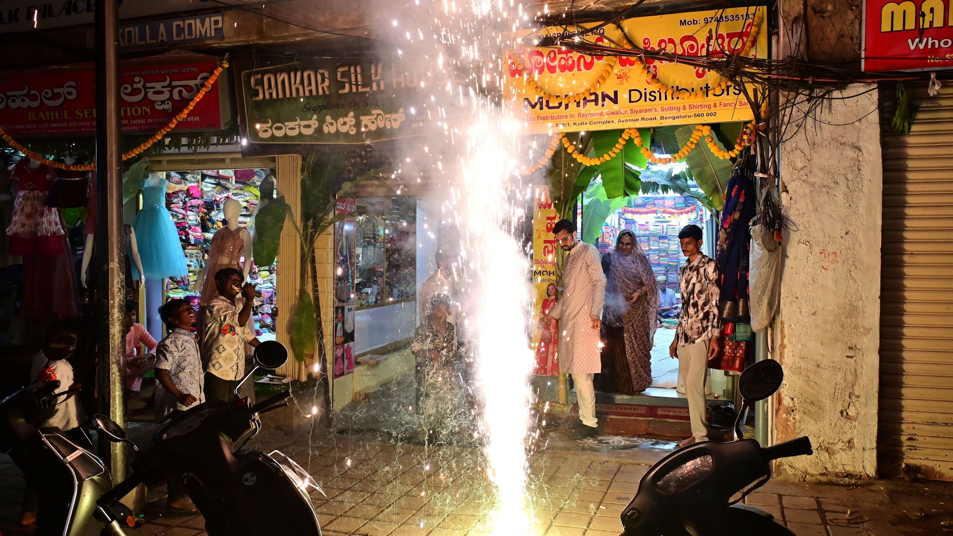 <div class="paragraphs"><p>A family celebrates Deepavali by bursting firecrackers and lighting lamps at Chickpet on Friday. </p></div>