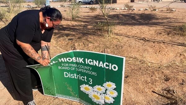 <div class="paragraphs"><p>April Ignacio removes a sign that had promoted her candidacy in a recent election, in Pisinemo</p></div>