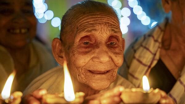 <div class="paragraphs"><p>An elderly woman lights a 'diya' to celebrate Diwali, a day after the festival, at the Pramod Talukdar Memorial Old Age Home, in Guwahati, Assam.</p></div>