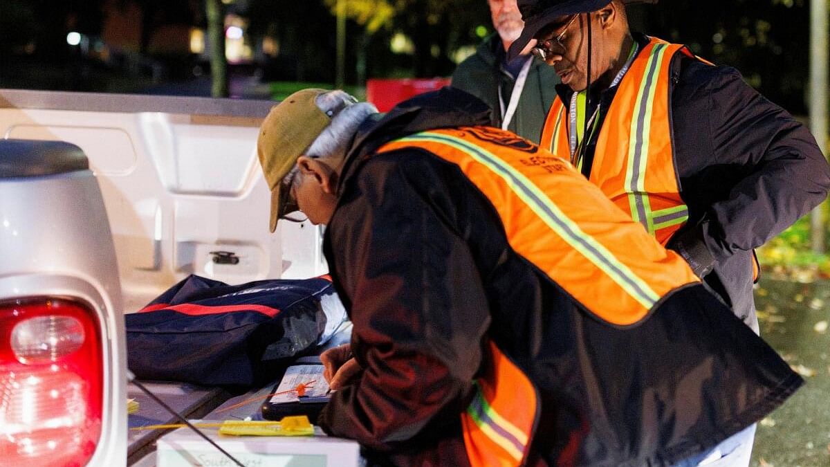 <div class="paragraphs"><p>Election commission workers collect ballots from the drop-off boxes, including one that was attacked earlier in the week in Washington.&nbsp;</p></div>