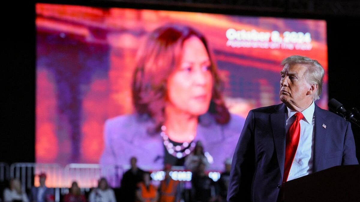 <div class="paragraphs"><p>Republican presidential nominee and former US President Donald Trump looks on as a screen shows Democratic presidential nominee US Vice President Kamala Harris during a campaign rally at Macomb Community College in Warren, Michigan.</p></div>