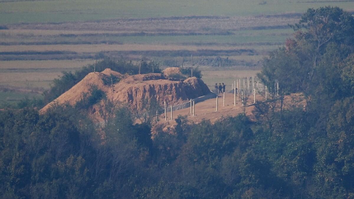 <div class="paragraphs"><p>North Korean soldiers stand near a military fence at North Korea's propaganda village Kaepoong</p></div>