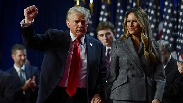 <div class="paragraphs"><p>Republican presidential nominee and former US President Donald Trump holds up a fist as he takes the stage with his wife Melania and son Barron.</p></div>