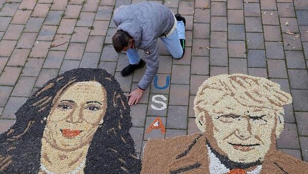 <div class="paragraphs"><p>Kosovo artist Alkent Pozhegu works on a mosaic made of grains showing portraits of Kamala Harris and Donald Trump, in Gjakova.</p></div>