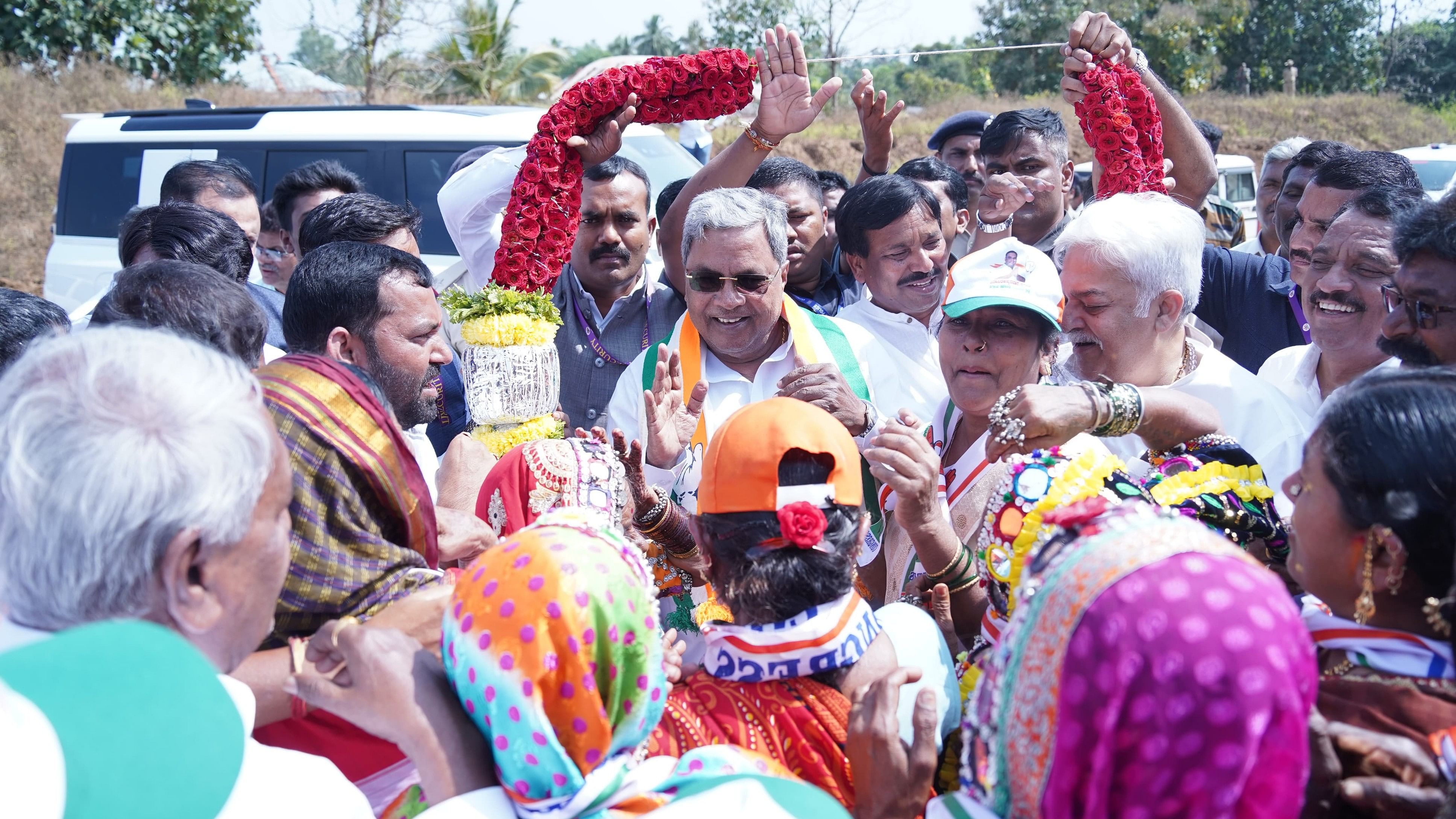 Chief Minister Siddaramaiah with Congress workers in Chandapura village of Shiggaon taluk in Haveri district on Tuesday. 