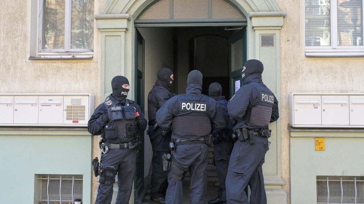 <div class="paragraphs"><p>Masked German police officers guard a house after having arrested eight suspected members of a right-wing militant group driven by racist ideology and conspiracy theories who had been training in warfare for the downfall of the modern German state, in Dresden, Germany.</p></div>