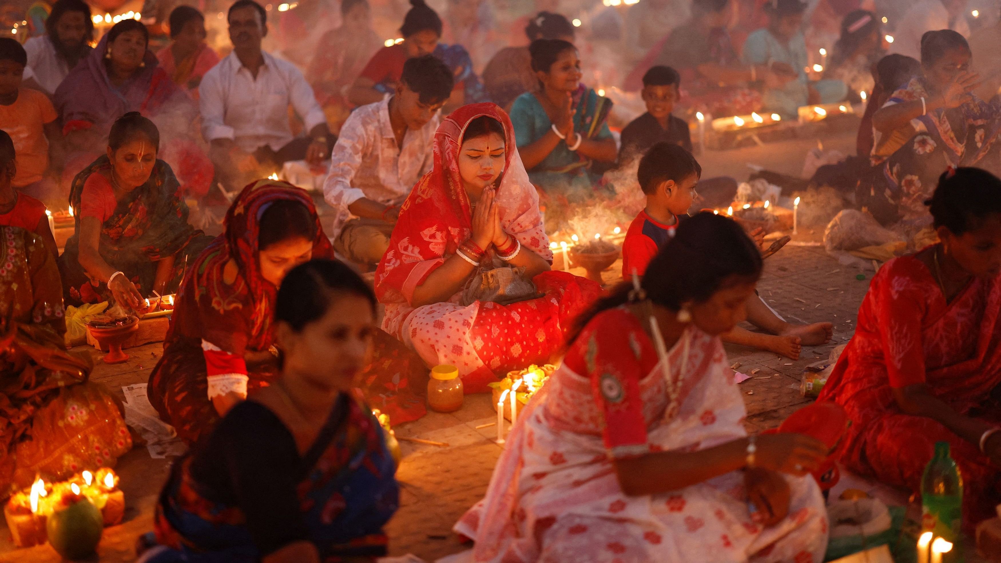 <div class="paragraphs"><p>Hindu devotees sit together in front of oil lamps, and pray to Lokenath Brahmachari, a Hindu saint and philosopher, as they observe the Rakher Upobash festival, at a temple in Narayanganj, Bangladesh, November 5, 2024.</p></div>