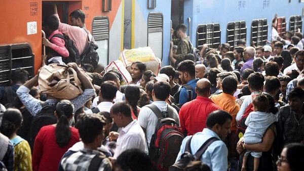 <div class="paragraphs"><p>Passengers in large numbers try to board a train during Chhath Puja celebrations, at Patna Railway Station.</p></div>