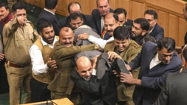 <div class="paragraphs"><p>Opposition legislators being marshalled out during a ruckus after BJP members protested over the special status resolution in J-K Assembly, in Srinagar, Friday.</p></div>