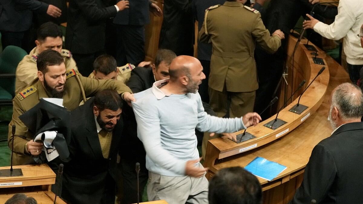 <div class="paragraphs"><p>Awami Ittehad Party MLA Sheikh Khurshid being marshalled out during a ruckus after BJP members protested over the special status resolution in J-K Assembly, in Srinagar, Friday, Nov 8, 2024.</p></div>