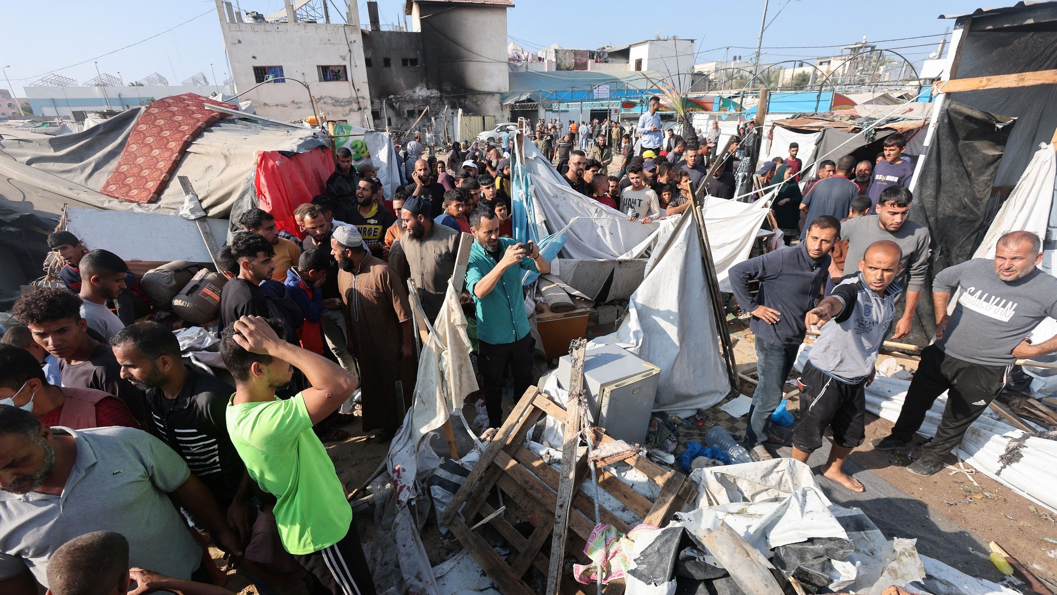 <div class="paragraphs"><p>Palestinians inspect the site of an Israeli strike on a tent housing displaced people, at Al-Aqsa Martyrs Hospital in Deir Al-Balah, in the central Gaza Strip.</p></div>