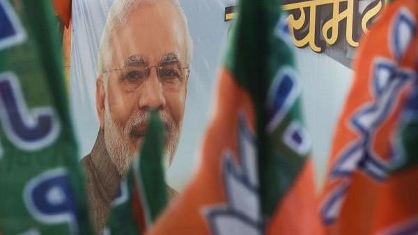 <div class="paragraphs"><p>Bharatiya Janata Party (BJP) workers carry flags past a poster of Indian Prime Minister Narendra Modi. Representative image</p></div>