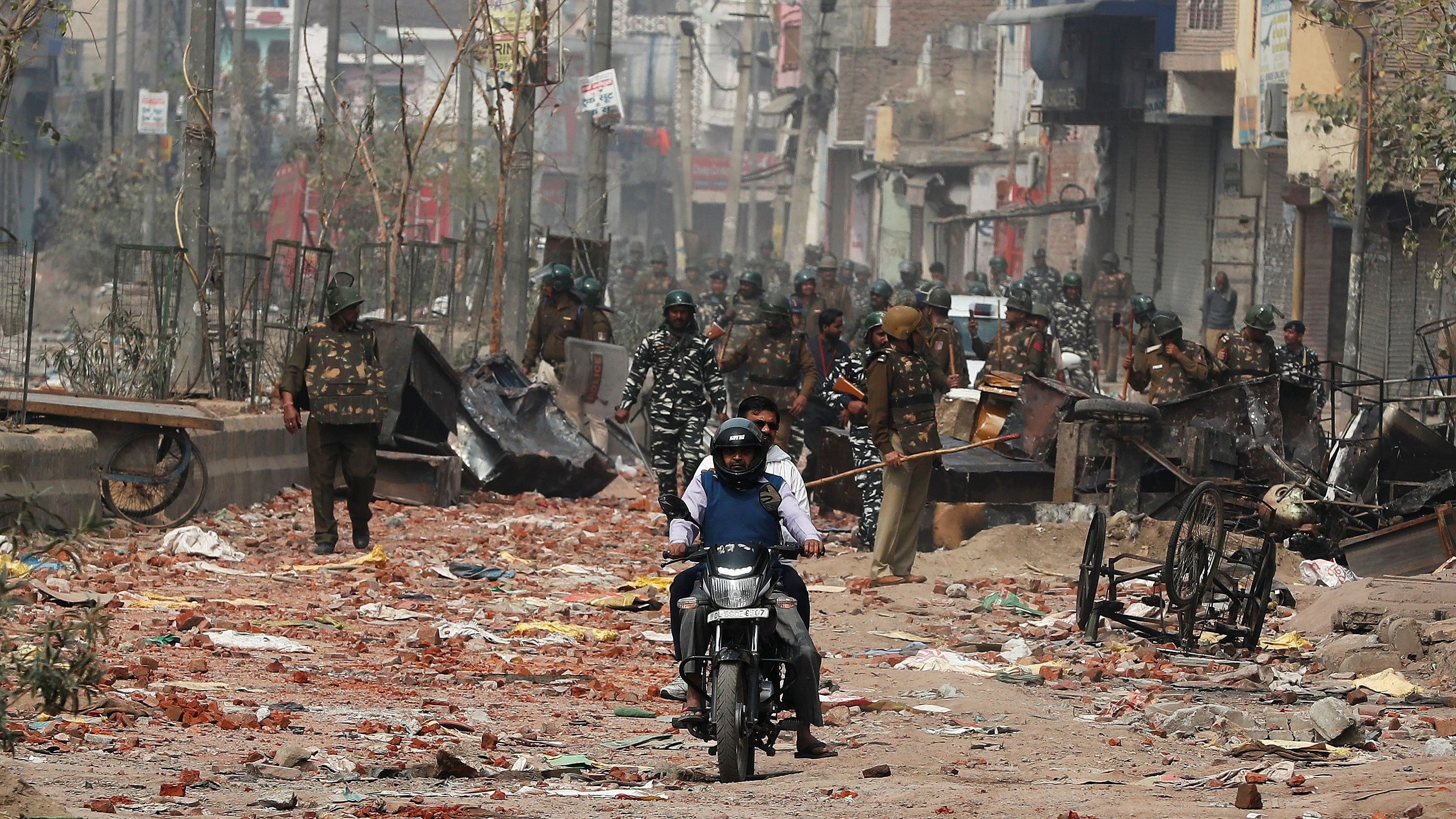 <div class="paragraphs"><p>Men ride a motorcycle past security forces patrolling a street in a riot affected area after clashes erupted between people demonstrating for and against a new citizenship law in New Delhi, India, February 26, 2020. </p></div>