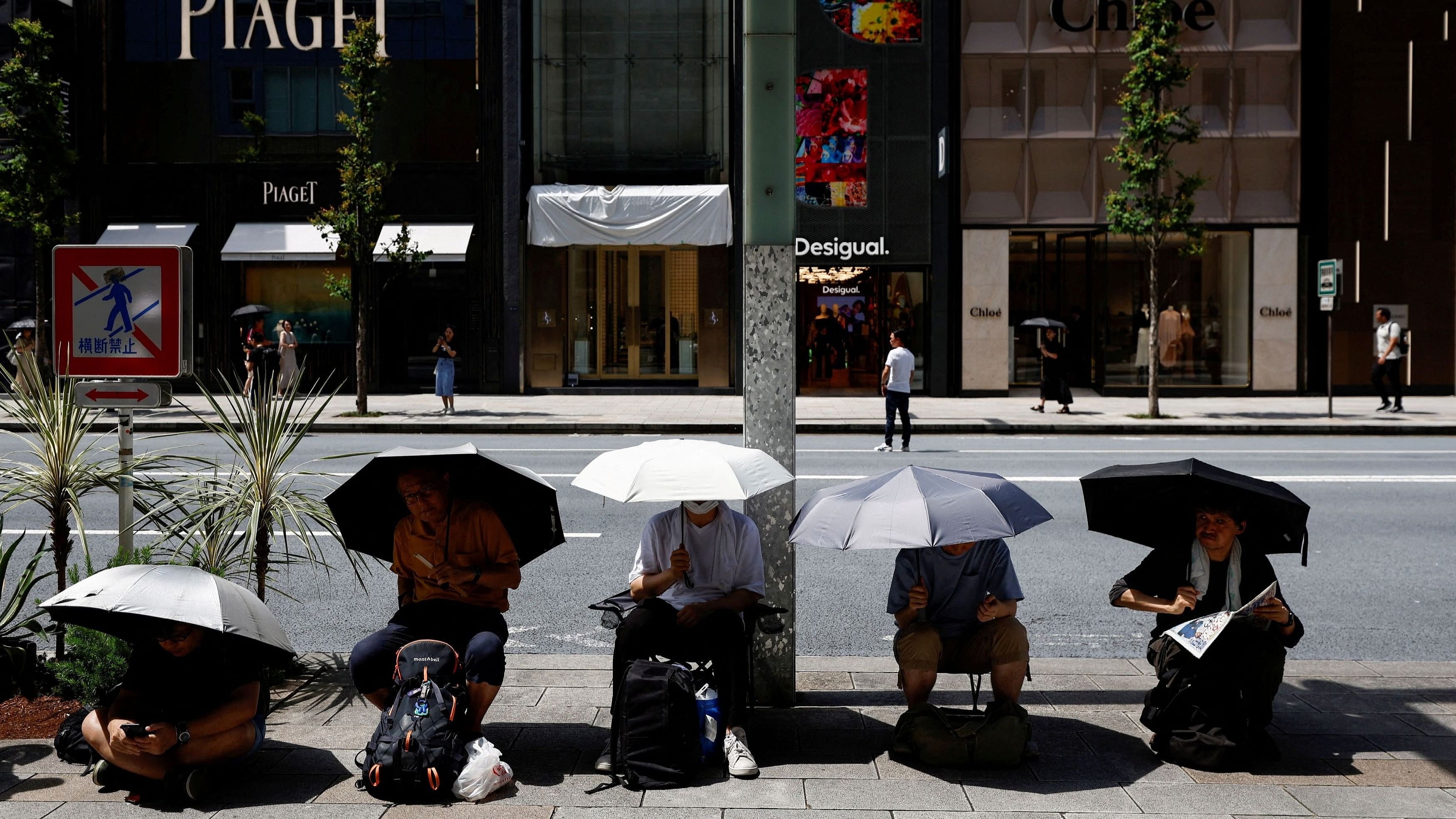 <div class="paragraphs"><p>People cover themselves with umbrellas during a hot summer day at Ginza shopping district in Tokyo, Japan, on August 11, 2024.     </p></div>