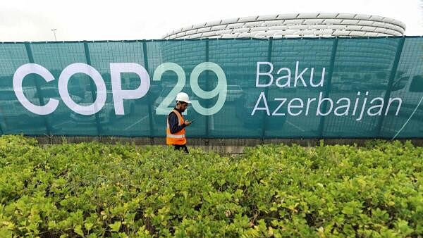 <div class="paragraphs"><p>A worker walks along a fence near the Baku Olympic Stadium, the venue of the COP29 United Nations Climate Change Conference, in Baku, Azerbaijan.</p></div>