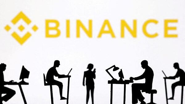 <div class="paragraphs"><p>Figurines with computers and smartphones are seen in front of Binance logo.&nbsp;</p></div>