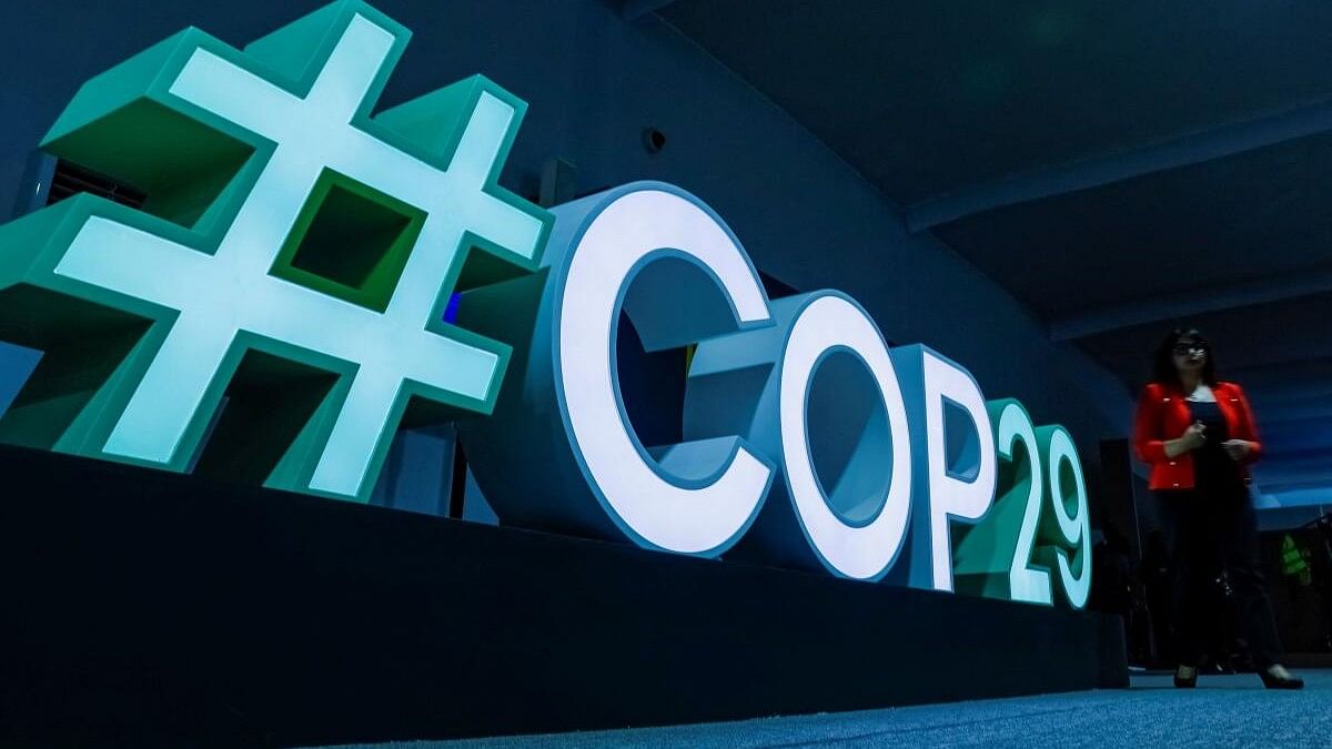 <div class="paragraphs"><p>A woman passes by a #COP29 sign during the United Nations climate change conference COP29 in Baku.</p></div>