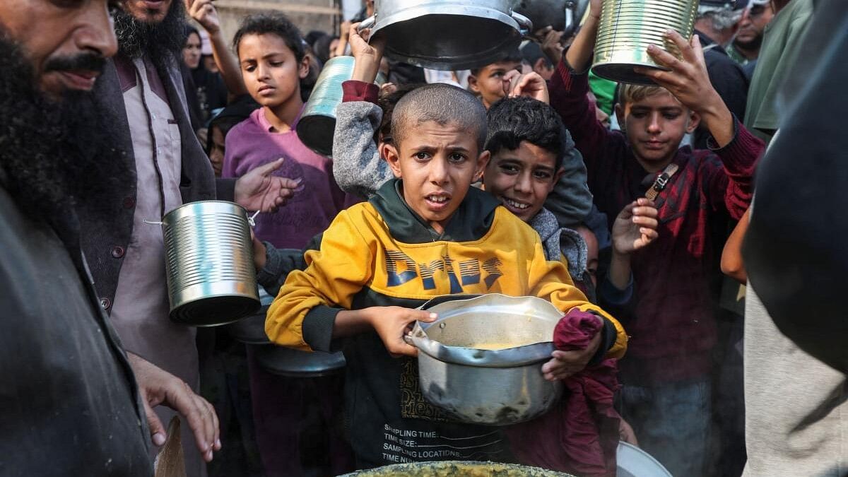 <div class="paragraphs"><p>Palestinians gather to receive meals cooked by a charity kitchen, amid the ongoing conflict between Israel and Hamas, in Deir Al-Balah, in the central Gaza Strip.</p></div>