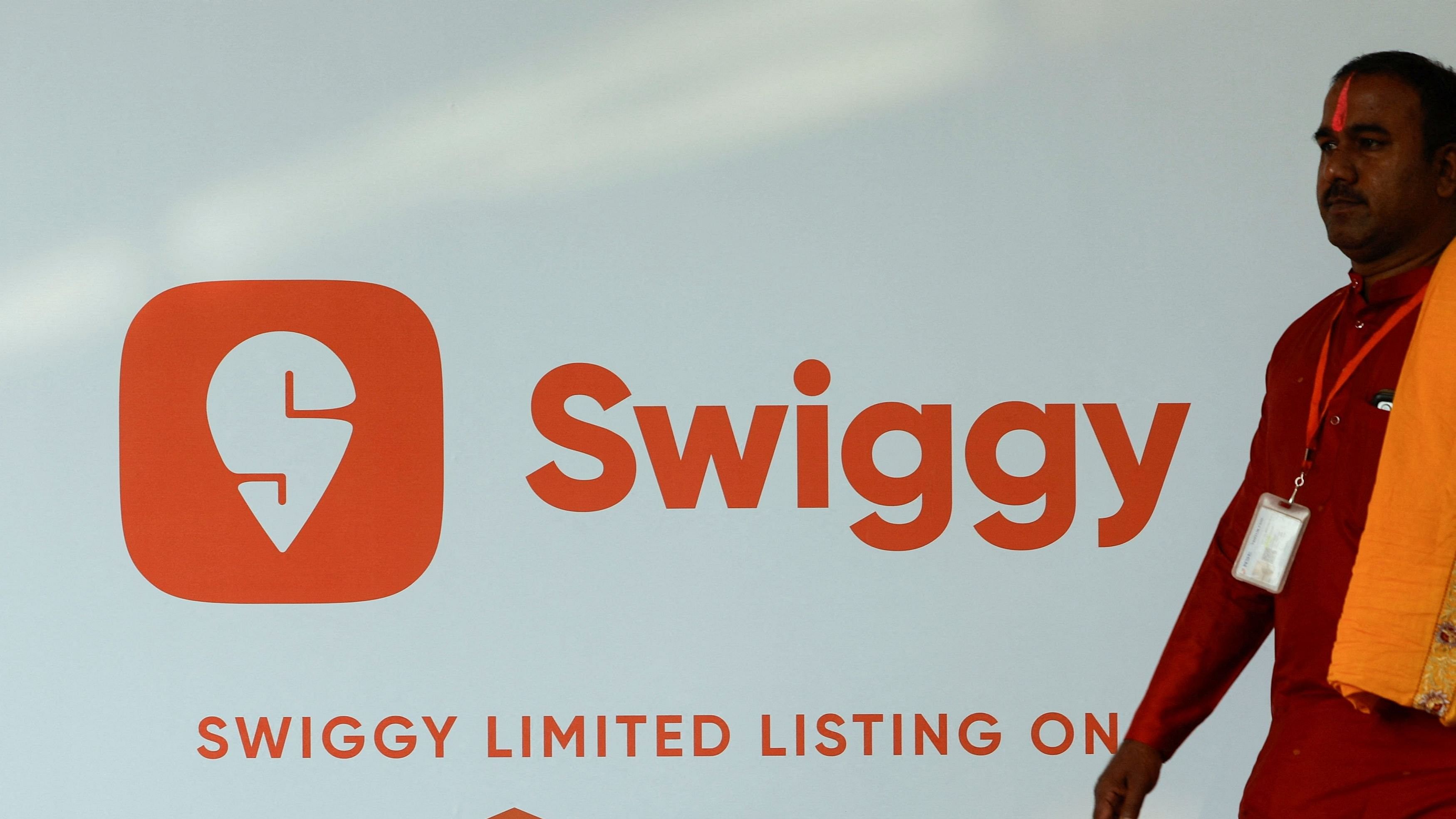 <div class="paragraphs"><p>A priest walks past a logo of Swiggy ahead of its Initial Public Offering  in Mumbai, India.</p></div>