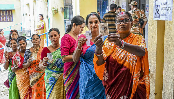 <div class="paragraphs"><p>Voters show their ID cards as they wait to cast their votes.</p></div>