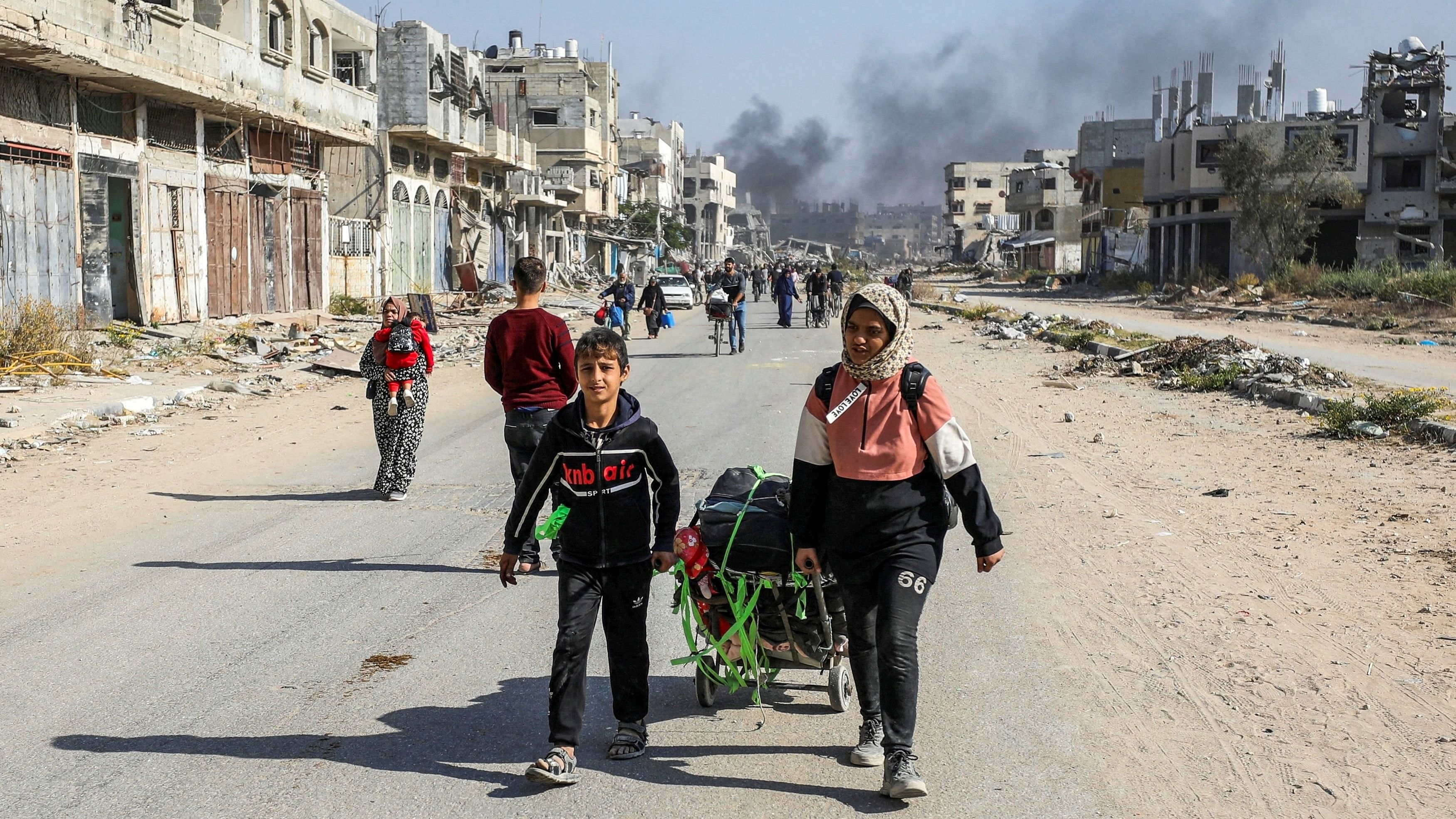 <div class="paragraphs"><p>Displaced Palestinians make their way after fleeing the northern part of Gaza amid an Israeli military operation, in Gaza City.</p></div>