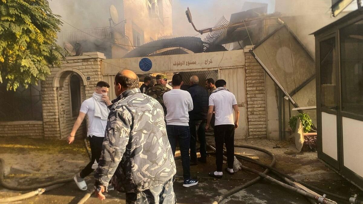 <div class="paragraphs"><p>Smoke rises as people gather at a damaged site after in the Damascus suburb of Mazzeh.&nbsp;</p></div>