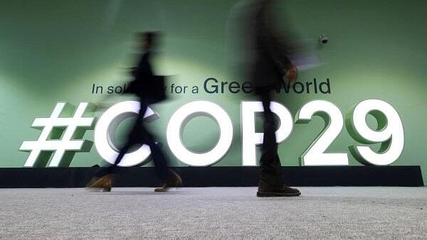 <div class="paragraphs"><p>People walk past a COP29 logo during the United Nations Climate Change Conference (COP29), in Baku.</p></div>