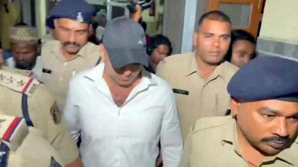 <div class="paragraphs"><p>Mumbai Police personnel take accused Faizan Khan from the Raipur court on a transit remand in actor Shah Rukh Khan death threat case, in Raipur.</p></div>